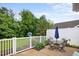 Back patio with outdoor seating, lush landscaping, and privacy fence at 306 Faith Dr, Gibsonville, NC 27249