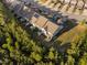 Aerial view of row homes with partial fences and small yards, with a nearby road and natural area at 310 Alamosa Pl, Cary, NC 27519
