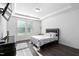 Bright bedroom with tray ceilings, large window, and dark hardwood floors at 310 Alamosa Pl, Cary, NC 27519