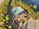 Aerial view of a community pool and pool house surrounded by a fence with parking to the right at 310 Alamosa Pl, Cary, NC 27519