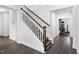 A staircase with hardwood steps, white risers, and wood railing at 310 Alamosa Pl, Cary, NC 27519