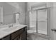 Bathroom featuring a walk-in shower, modern sink with cabinet, and neutral tile flooring at 3122 Jones Lake Rd, Fuquay Varina, NC 27526