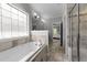 Bright bathroom with a soaking tub, glass-enclosed shower, and neutral tile flooring at 3122 Jones Lake Rd, Fuquay Varina, NC 27526