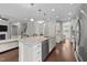 Open-concept kitchen island with a sink, marble countertops, and stainless steel appliances at 3122 Jones Lake Rd, Fuquay Varina, NC 27526