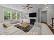 Bright living room featuring large windows, a fireplace, and a plush sectional sofa at 3122 Jones Lake Rd, Fuquay Varina, NC 27526