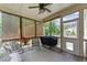 Cozy screened porch featuring a ceiling fan, comfortable seating, and an outdoor grill at 3122 Jones Lake Rd, Fuquay Varina, NC 27526