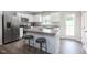 Bright kitchen featuring stainless steel appliances, an island with seating, and white cabinetry at 314 N Coral Bells Way, Four Oaks, NC 27524