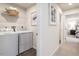 Bright laundry area with modern washer, dryer, storage shelf, and stylish decor for convenient chores at 314 N Coral Bells Way, Four Oaks, NC 27524