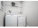 Efficient laundry room equipped with a washing machine, dryer, and overhead shelving at 314 N Coral Bells Way, Four Oaks, NC 27524
