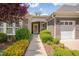 Charming entryway with a covered porch, manicured landscaping, and a welcoming front door at 316 Ibis Ln, Durham, NC 27703