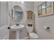 Bright half bathroom features a pedestal sink and decorative mirror at 316 Ibis Ln, Durham, NC 27703