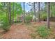 Lush backyard with mature trees, a picket fence, and a view of the rear of the house at 3405 Bonaparte Way, Durham, NC 27707