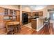 Eat-in kitchen featuring wood cabinetry, black appliances, and breakfast bar at 342 Faith Dr, Gibsonville, NC 27249