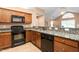 Beautiful kitchen featuring granite countertops, warm wood cabinetry, and modern appliances at 342 Faith Dr, Gibsonville, NC 27249