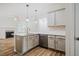 Bright kitchen features an island, white quartz countertops, stainless steel appliances, and stylish pendant lighting at 361 Anterbury Dr # B, Apex, NC 27502