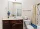 Well-lit bathroom featuring a framed mirror, wood vanity, and a shower with a patterned curtain at 3904 Freemark Ln, Fuquay Varina, NC 27526