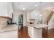 Well-equipped kitchen with island, granite countertops, white cabinetry and hardwood floors at 3904 Freemark Ln, Fuquay Varina, NC 27526