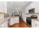 Modern kitchen features granite countertops, stainless steel appliances, and an open view to the dining area at 3904 Freemark Ln, Fuquay Varina, NC 27526