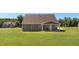 Backyard view of a two-story home with a covered patio and large grassy area, surrounded by trees at 3909 Mendenhall Dr, Zebulon, NC 27597