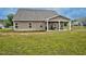 Expansive backyard featuring a covered patio, a grill, lush green grass, and a glimpse of the neighborhood at 3909 Mendenhall Dr, Zebulon, NC 27597