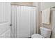Classic bathroom with a toilet, a white shower curtain, and a towel hanging on the wall at 3909 Mendenhall Dr, Zebulon, NC 27597