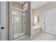 Bright bathroom featuring a glass door shower, a white tub, and neutral-colored walls at 3909 Mendenhall Dr, Zebulon, NC 27597