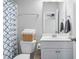 Bright bathroom with a white vanity, mirror, and toilet with decorative basket for added storage at 3909 Mendenhall Dr, Zebulon, NC 27597