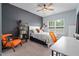 Stylish bedroom with a ceiling fan, a desk, an orange chair, and large windows for natural light at 3909 Mendenhall Dr, Zebulon, NC 27597