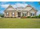 Charming home with a stone and wood exterior, landscaped lawn, and beautifully manicured shrubs and flower beds at 3909 Mendenhall Dr, Zebulon, NC 27597