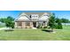 Charming home boasts a stone and siding facade, complemented by a lush green lawn and manicured landscaping at 3909 Mendenhall Dr, Zebulon, NC 27597