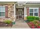 Inviting front entrance with stone accents, a covered porch, and a well-maintained walkway at 3909 Mendenhall Dr, Zebulon, NC 27597