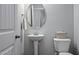 Cozy powder room with a pedestal sink, oval mirror, and neutral wall color at 3909 Mendenhall Dr, Zebulon, NC 27597