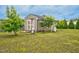 Backyard shed with a swing and chairs surrounded by beautiful trees and lush greenery at 3909 Mendenhall Dr, Zebulon, NC 27597