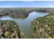 Scenic aerial view of a lake surrounded by lush forests and blue skies at 3940 Lake Ferry Dr, Raleigh, NC 27606