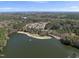 Scenic aerial view features a tranquil lake, surrounded by trees and an apartment complex with city views at 3940 Lake Ferry Dr, Raleigh, NC 27606