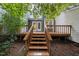 The back deck with stairs offers an outdoor space for relaxation and entertaining amidst lush greenery at 3940 Lake Ferry Dr, Raleigh, NC 27606