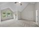 Bedroom features a vaulted ceiling, neutral carpeting, and a bright arched window at 3940 Lake Ferry Dr, Raleigh, NC 27606
