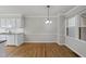 A dining area featuring hardwood floors, a modern chandelier and bright windows offering natural light at 3940 Lake Ferry Dr, Raleigh, NC 27606