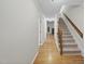 A bright hallway with hardwood floors and carpeted stairs leading to the upper level at 3940 Lake Ferry Dr, Raleigh, NC 27606