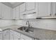 Kitchen detail showing stainless sink with granite countertops and white cabinets at 3940 Lake Ferry Dr, Raleigh, NC 27606