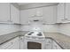 Bright kitchen features white cabinets, granite countertops, subway tile backsplash and electric stove at 3940 Lake Ferry Dr, Raleigh, NC 27606