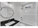 Bathroom with modern features, including a round mirror and shower-tub combo at 401 N Raiford St, Selma, NC 27576