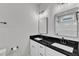 Bathroom with double vanity, black countertop, white cabinets, and modern fixtures at 401 N Raiford St, Selma, NC 27576