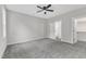 A spacious bedroom featuring carpet floors, a ceiling fan, and multiple doors to closets and the bathroom at 401 N Raiford St, Selma, NC 27576