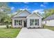 Charming one-story home featuring black shutters, craftsman columns, and a well-manicured lawn at 401 N Raiford St, Selma, NC 27576