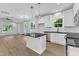 Open concept kitchen with island and black countertop and stainless steel appliances that connects to a large, bright living space at 401 N Raiford St, Selma, NC 27576