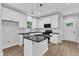 Modern kitchen featuring white cabinets, a black countertop island, stainless steel appliances, and wood flooring at 401 N Raiford St, Selma, NC 27576