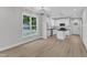 Open living room with luxury vinyl plank flooring flowing into a modern white kitchen at 401 N Raiford St, Selma, NC 27576