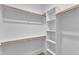 Walk-in closet with built-in shelving and wooden rods for hanging clothes at 401 N Raiford St, Selma, NC 27576