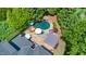Aerial view of backyard featuring a pool with a grotto, outdoor dining area, and lush landscaping at 404 Brightling Way, Holly Springs, NC 27540
